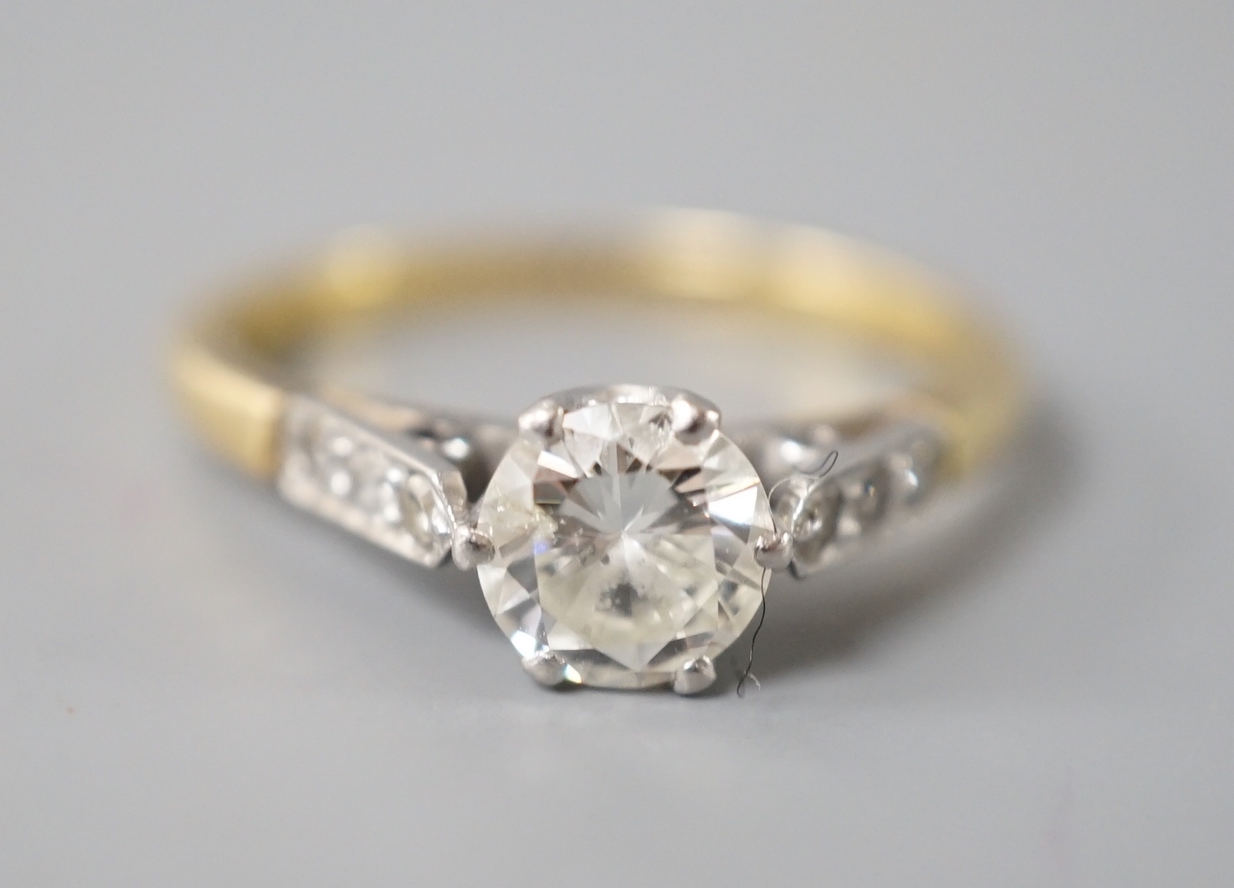 An 18ct & plat, single stone diamond ring, with diamond set shoulders, size N, gross weight 2.7 grams